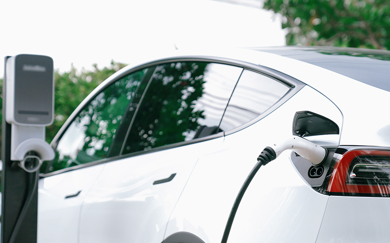 White electric car charging at charging station in Singapore.