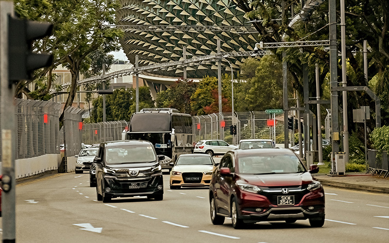 Traffic flowing along Singapore city roads with Esplanade building background.